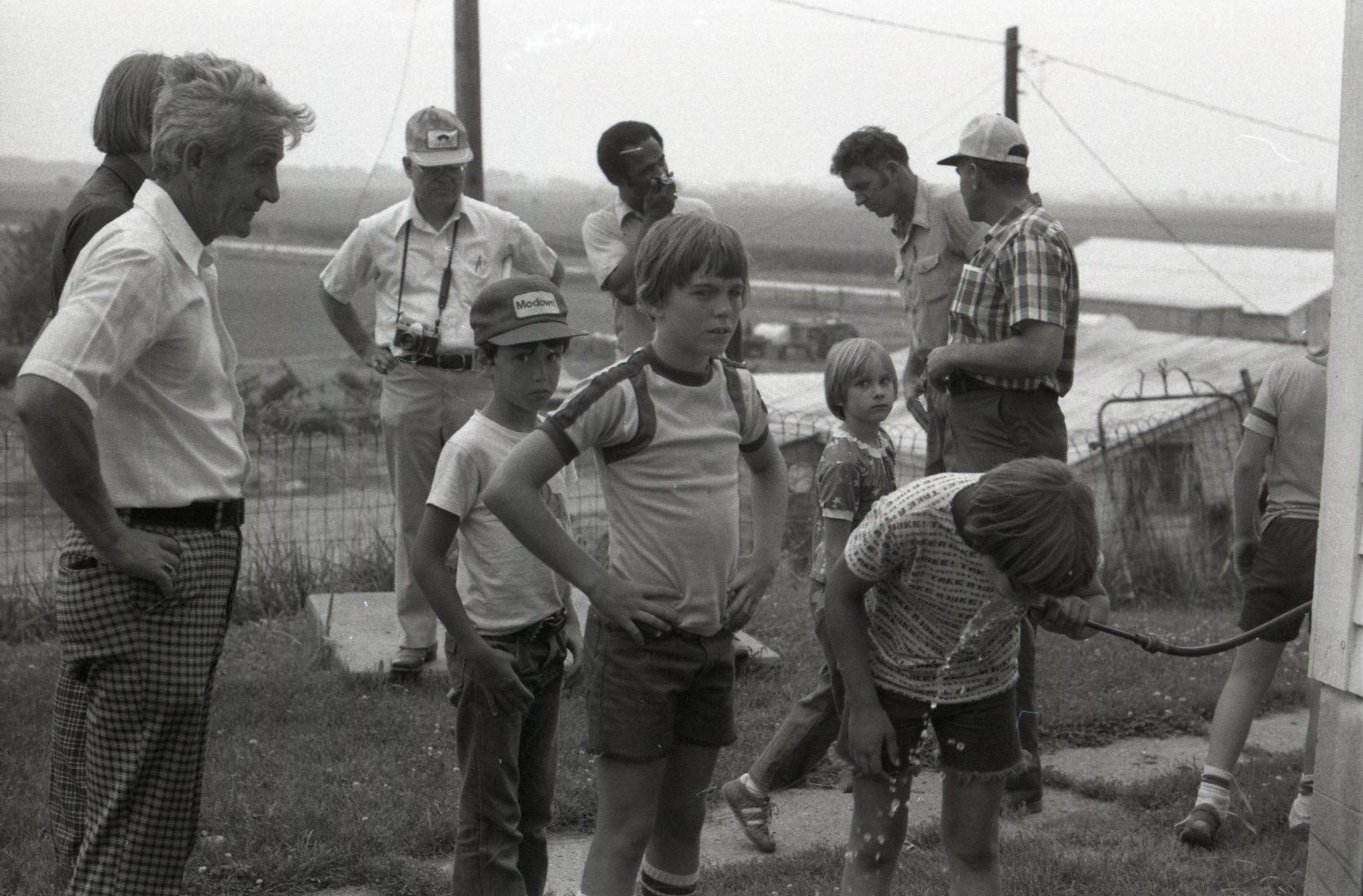 Adults and children stand in a group