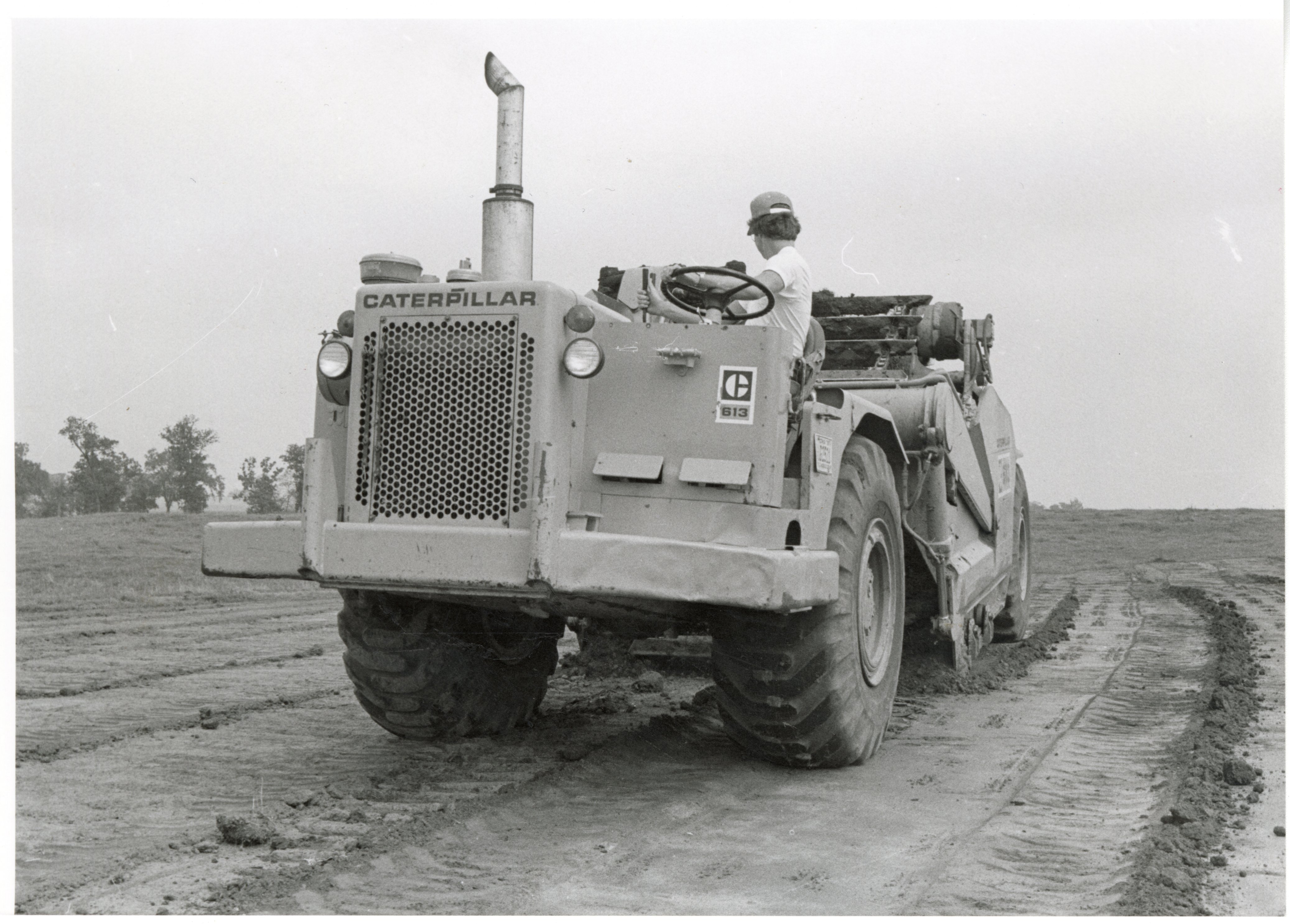 1979  Three views of man driving Caterpillar 613 earthmoving machine