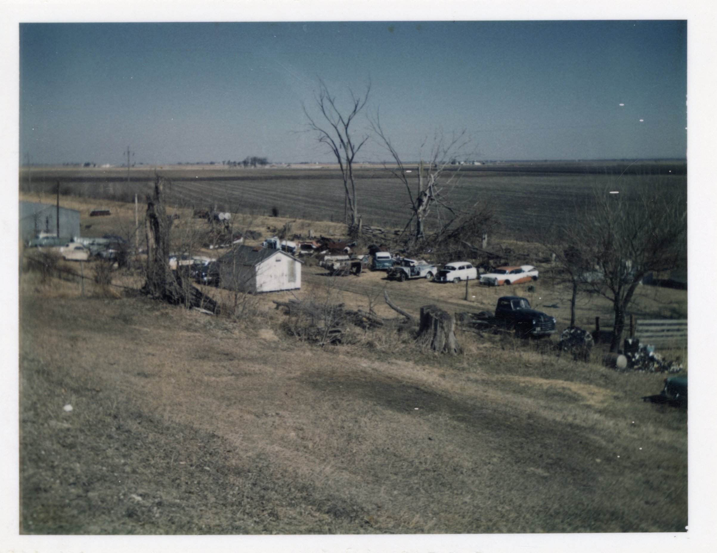 Junkyard of cars by field