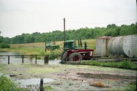 Tractors sit in fields near flooded areas