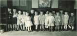 Small children standing against a wall in a playroom, The University of Iowa, 1920s