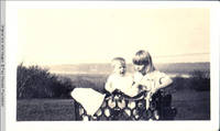 Baby Vidie And Frindy Burden on bench between Grey house and White house
