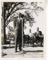 Man in Suit Talks into Microphone