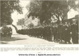 One section of a commencement procession walking down Washington St., The University of Iowa, 1910s
