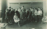 Teacher demonstrating spinning wheel for students, The University of Iowa, 1920s