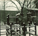 Small child climbing on a jungle gym in the snow, The University of Iowa, January 1938