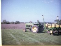 Man on Tractor Pulling Trailer with Chemicals