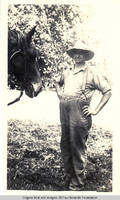 John Heitzman with horse in hayfield