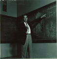 Physics instructor pointing at an equation on chalkboard, The University of Iowa, 1940s