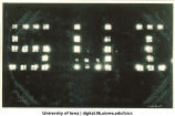 Building windows lit up to spell SUI as part of Homecoming celebration, The University of Iowa, 1940s?