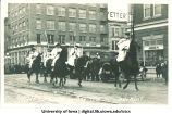 Men with surveying poles on horseback in Mecca Day parade, The University of Iowa, 1920