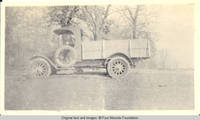 Unknown man in early model truck with Four Mounds lettering on the door
