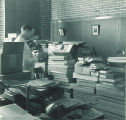 Man organizing boxes of plant specimens, The University of Iowa, 1930s