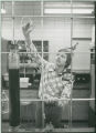 Young researcher checking equipment in laboratory, 1980