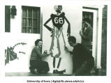 Students painting design on building for Homecoming, The University of Iowa, 1940s