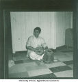 Man dressed in a traditional costume playing drums, 1960s