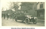 Marching band behind officials in car, Homecoming parade, The University of Iowa, 1917