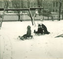 Children playing on sleds on a snowy playground, The University of Iowa, January 1938