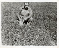Dewey Harper Kneels in Grass