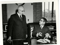 Men conversing over document