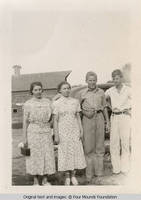 Four people standing by car