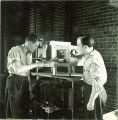 Men working with tongs and chemistry equipment, The University of Iowa, 1930s