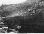 Man near cap rock and crevice, Iowa, late 1890s or early 1900s