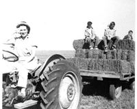 Title page; Evelyn Birkby driving tractor pulling hay wagon, Shenandoah, Iowa, 1950s