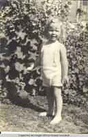 Vidie Burden by Hollyhocks outside White house