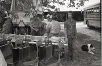 Men stand under tree during a meeting