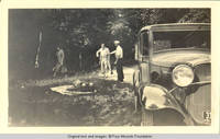 Unknown men with fish on stick and unknown woman walking