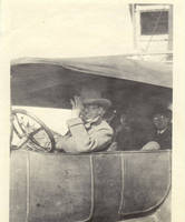 Three unknown men driving in car with driver waving