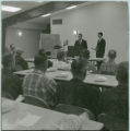 Agricultural education lecturer speaking to a class of adult men, 1966.