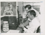 Two researchers examining an object in a laboratory, with an inset photo of a man with four baby pigs