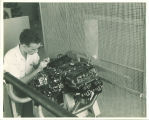 Engineering student working on engine in engineering laboratory, The University of Iowa, 1939