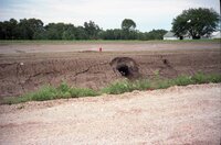 Hole in dirt wall by road