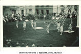Women in costume dancing on the Pentacrest lawn near a maypole, The University of Iowa, June 1924