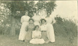 Women posing near pine tree, Iowa, 1900s