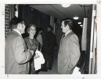 1970s  Two men and a woman talk in hallway