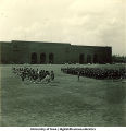 ROTC Scottish Highlanders and soldiers standing near football stadium, The University of Iowa, 1950s