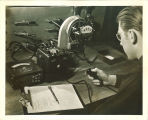 Engineering student working with electrical meters and gauges in engineering laboratory, The University of Iowa, 1939