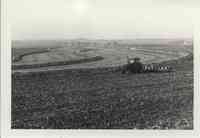 Gil Winter cultivating the field on a tractor