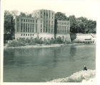 Man sits across river from Hydraulic Laboratory, the University of Iowa, circa 1933