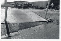 Uneven pavement in front of dirt pile