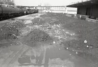Train parked by station with dirt