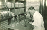 Student performing lab experiment, The University of Iowa, 1920s?