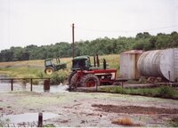 Tractors sit in fields near flooded areas