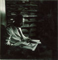 Man examining pressings of plants, The University of Iowa, 1930s