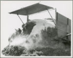 Grass ensilage being dumped into pit silo