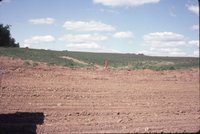 Bulldozed earth near gravel road
